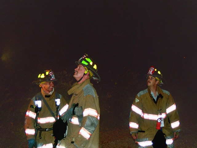 Firefighter Chris Carmody, Sergeant Rob Schombert and Firefighter Bill Flanagan look on as Ladder 12's master stream darkens the fire